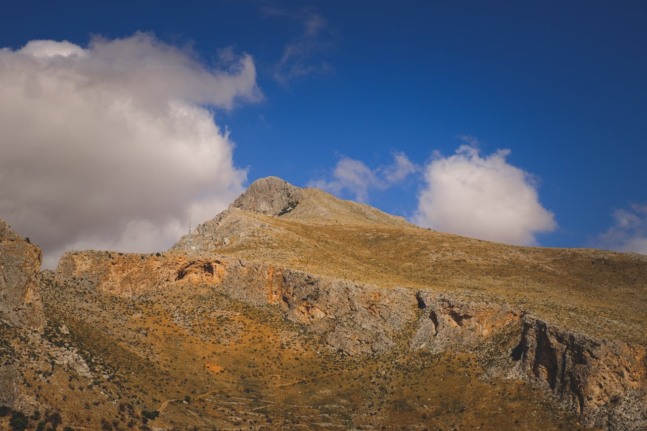 A mountain with a blue sky and clouds